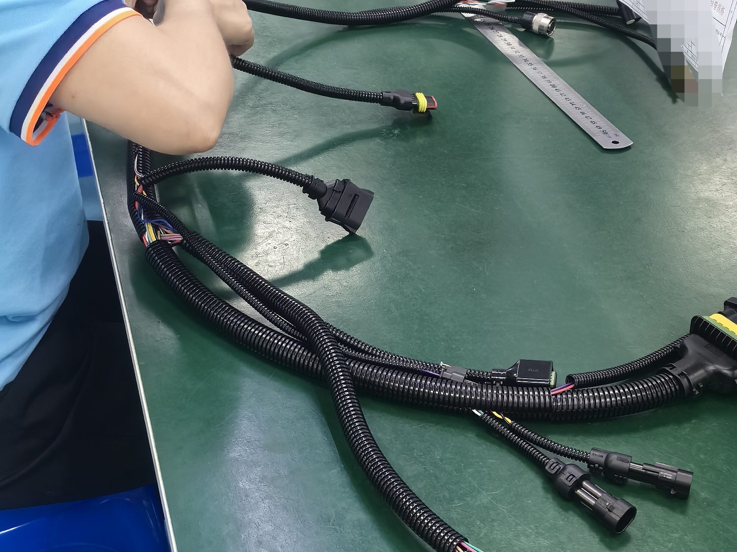 Bench assembly of a heavy-gauge harness with corrugated conduit