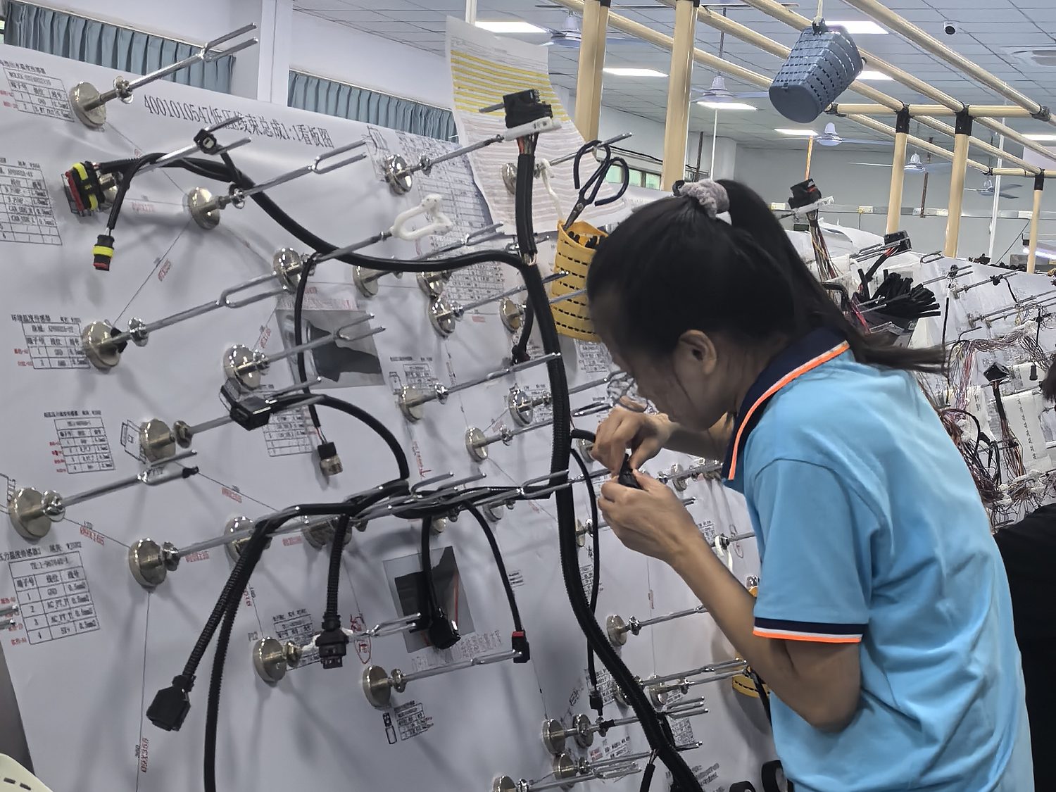 Operator building a harness on a forming board to the master layout